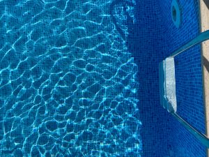 an aerial view of a swimming pool showing natural light ripple through the water.